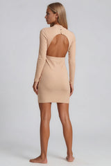 Woman wearing a beige dress with cut-out back on a white background